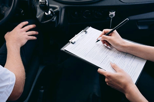 An RV owner inspecting their vehicle with a clipboard and documents